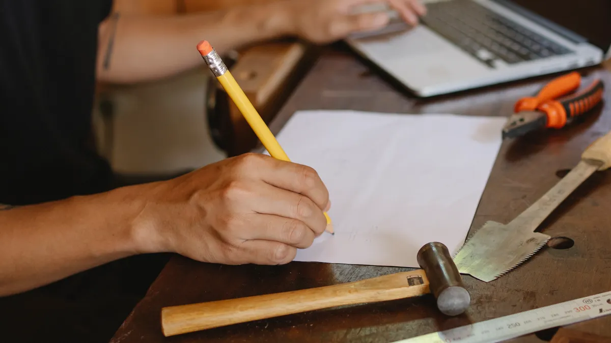 Best writing tools for agencies and client approvals Best writing tools for agencies and client approvals — Crop artisan writing on paper and typing on laptop indoors