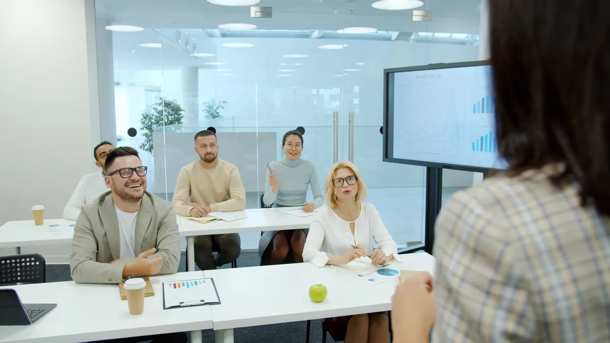 Content operations dashboard metrics for writing teams meeting room with people facing a chart display