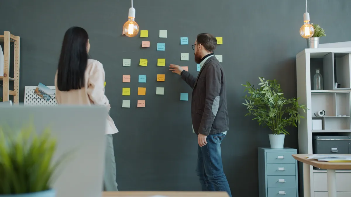 Content workflow templates for blogs, newsletters, and thought leadership Coworkers arranging sticky notes on an office wall