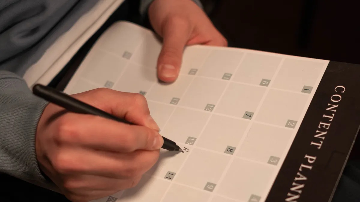 Editorial calendar software for content teams: how it works — Person Writing on a Calendar Planner