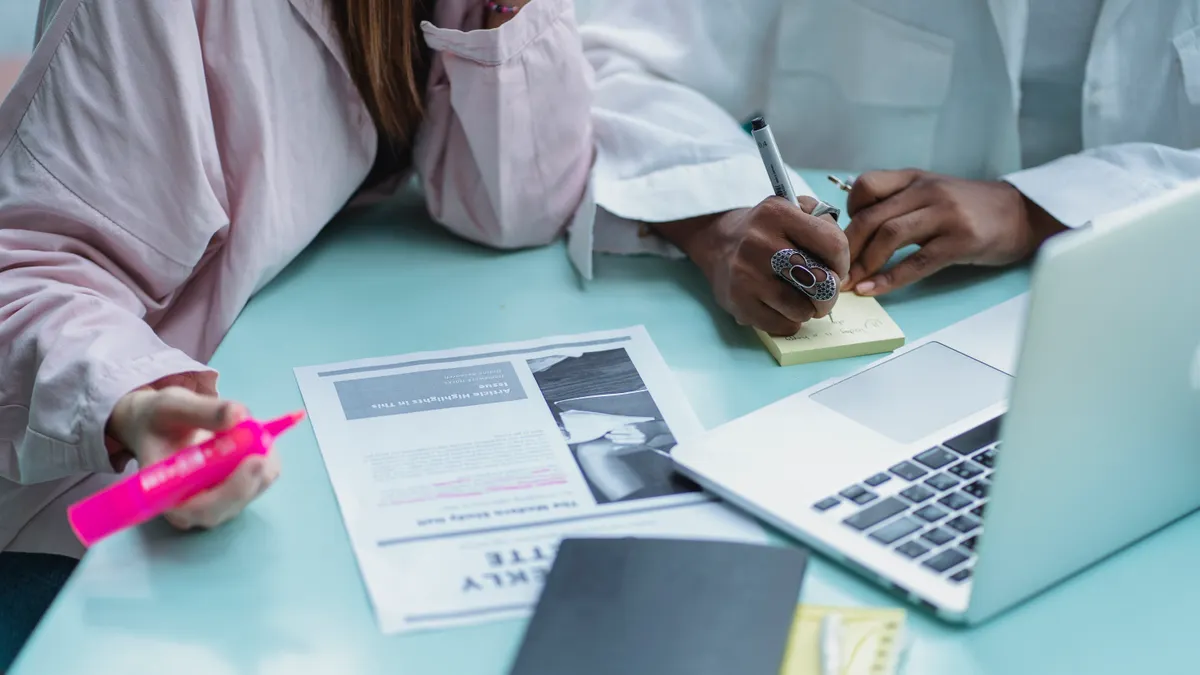 Writing tools for teams: what features matter for collaboration Writing tools for teams: what features matter for collaboration — Crop multiracial students writing on sticky notepad ne